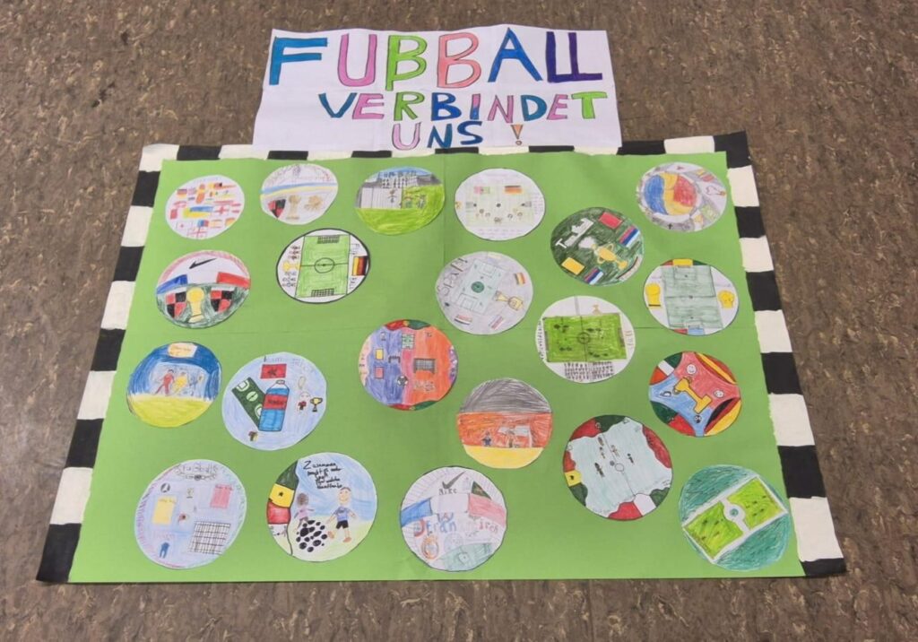 Ein Kunstwerk für Kinder, das bunte Zeichnungen von Fußballthemen in Kreisen zeigt, mit dem deutschen Text FUBBALL VERBINDET UNS am oberen Rand.